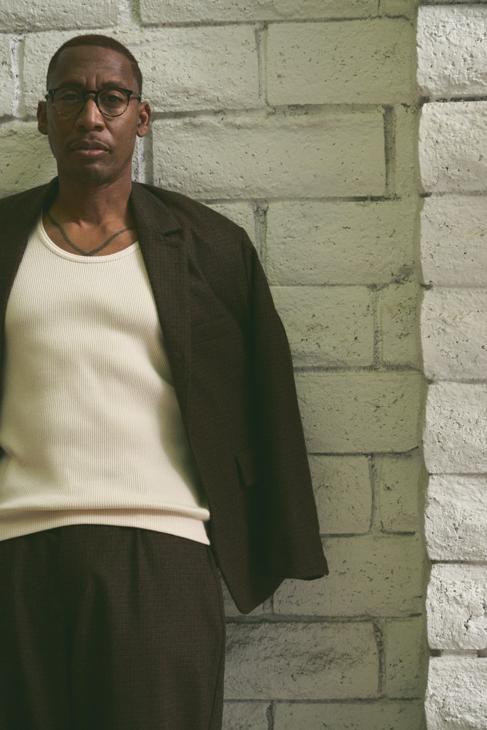 Man posing in front of bricks