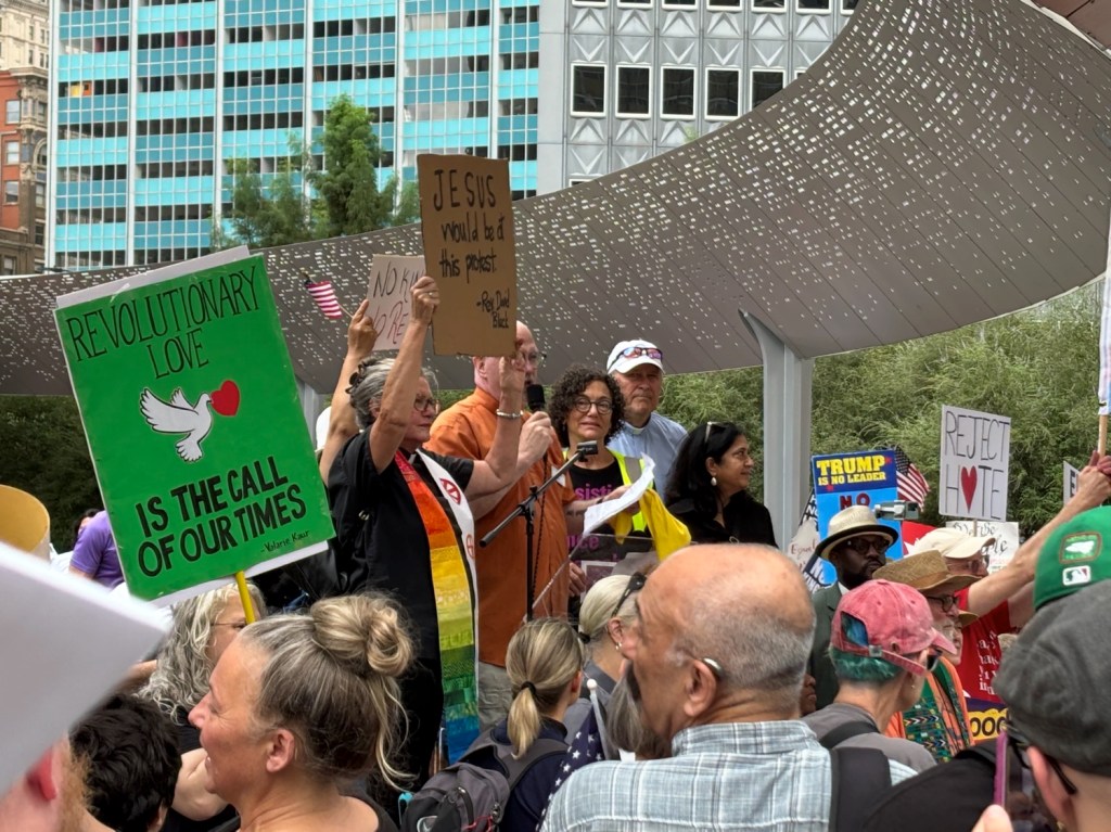 The Rev. Erick Folkerth kicks off at podium at Dallas No KIngs protest.