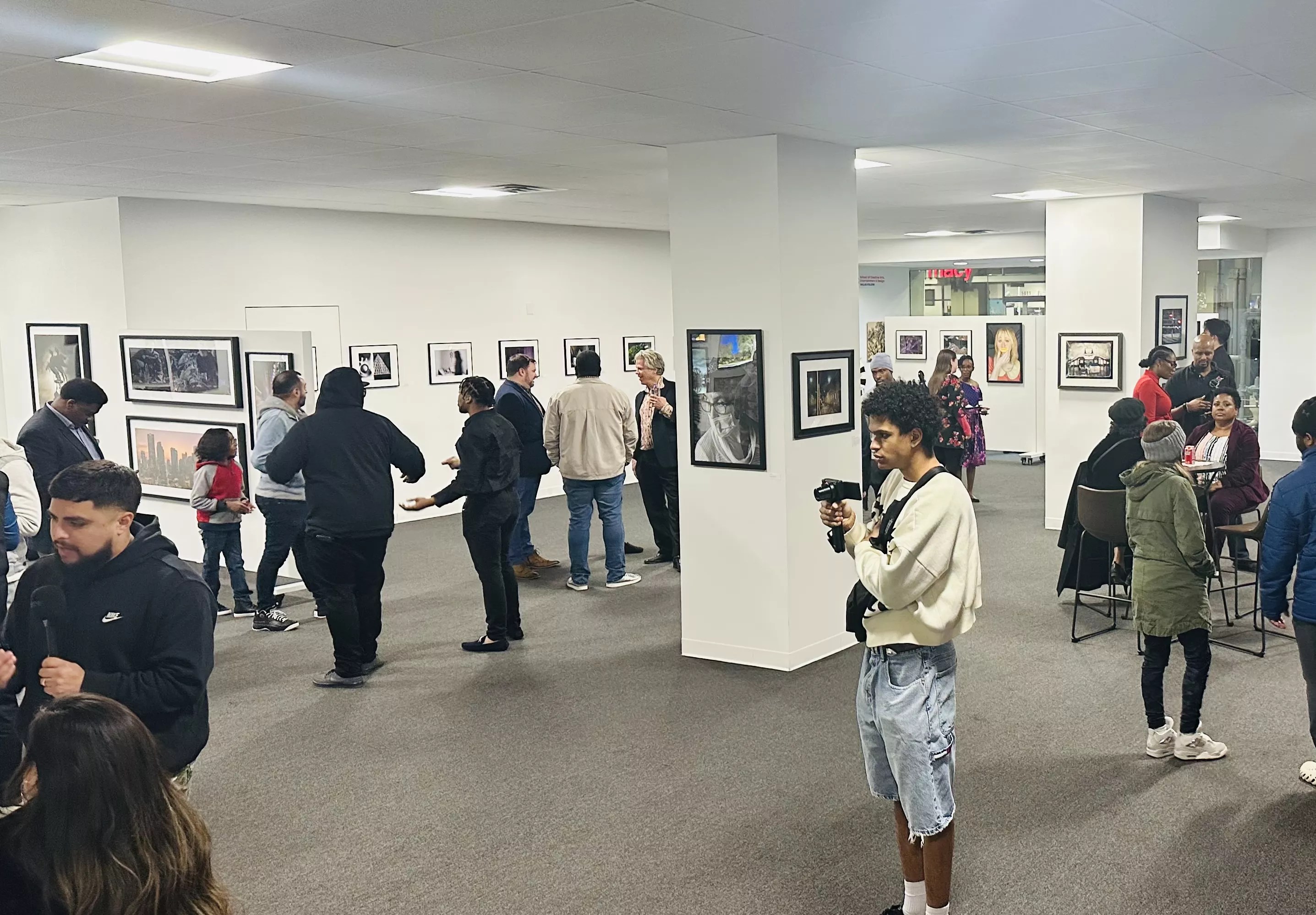 Patrons check out art at <i>A Decisive Vision: New Perspectives from Dallas College Faculty and Students,</i> on display at the Adolphus Tower Gallery through March 29.