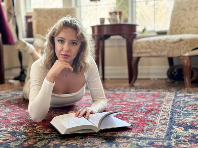 Author Ryann Bee Gordon poses with a book, her trippy new debut novel The Bridge Inside.