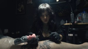 A woman tattooer works on a client at Black Rose Tattoo in Mansfield.