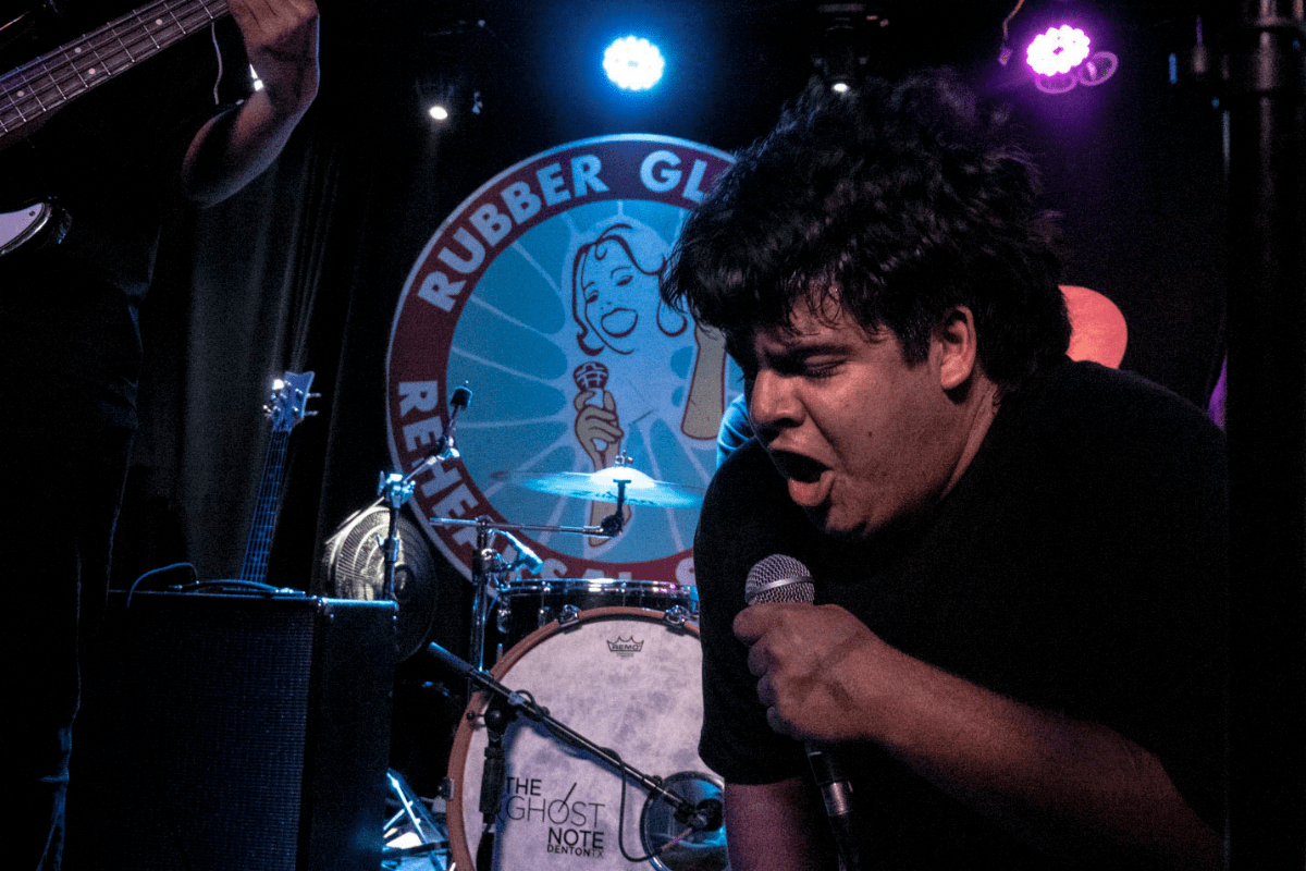 A man from a band screaming into a microphone
