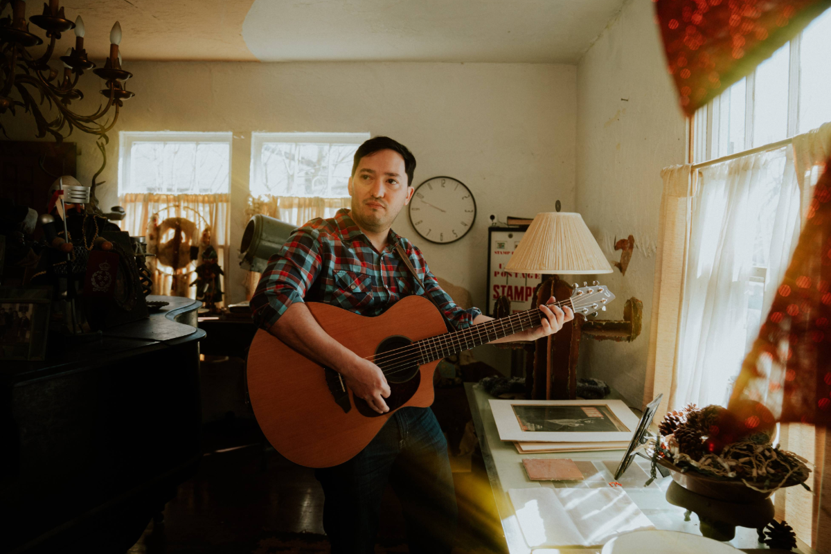 man playing guitar at home