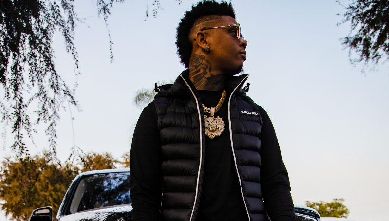 Man posing in front of a car